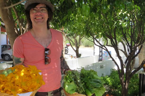Koch Volker trägt Zucchini-Blüten in der Hand