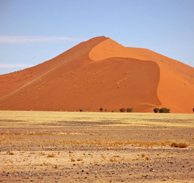 Sossusvlei ist ein Traum in Rot: Die berühmte Dünenlandschaft, wohl die älteste Wüste der Welt, ist Namibias Wahrzeichen. Die Salzpfanne des Sossusvleis bildete sich am Tsauchab-Fluss, als der versandete und eine Senke aus Salz und Lehm hinterließ. Ringsum ragen majestätisch die roten Dünen auf
