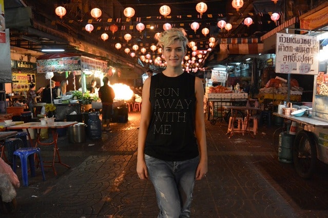 Autorin Mia Bühler steht am Abend in China Town auf der Straße, über ihr Laternen, neben ihr Marktstände