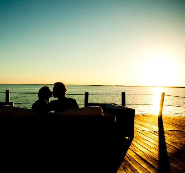 Paar sitzt auf der Terrasse mit Sonnenuntergang