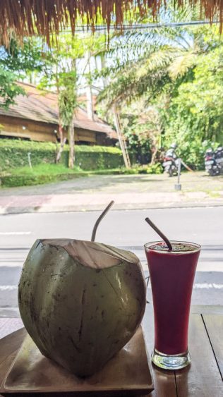 Eine Kokosnuss und ein frischer Saft in einem Straßencafé