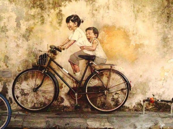 Streetart von Ernest Zacharevic: Zwei Kinder beim Fahrradfahren