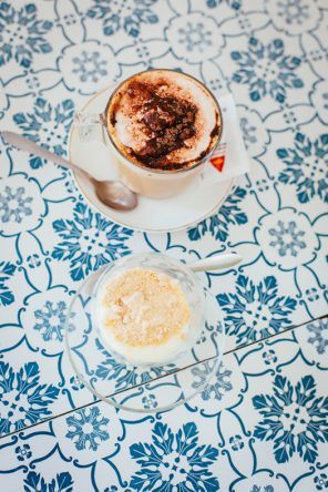 Kaffee und weiße Milchcreme mit Kekskrümeln im Café com Calma (Fotocredit: Thea Neubauer)