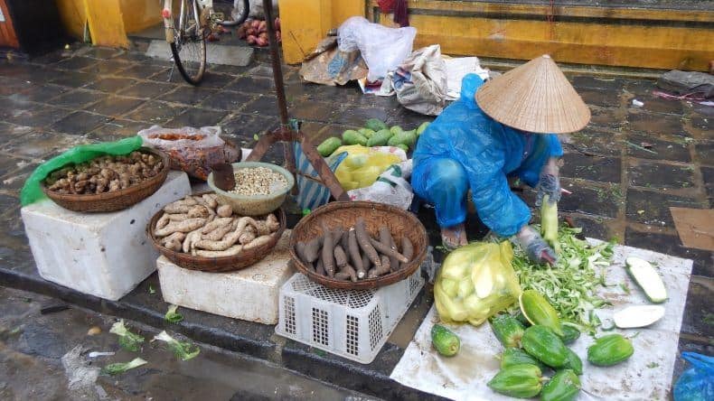 Papaya und Wurzelgemüse wird von dem Verkäufer geschält und vorbereitet
