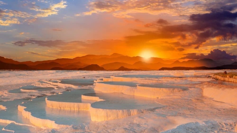 Blick auf einen Sonnenuntergang über den Kalksteinterrassen von Pamukkale