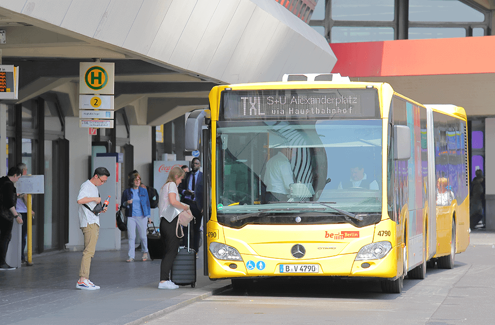 Mit dem Bus zum Flughafen fahren.