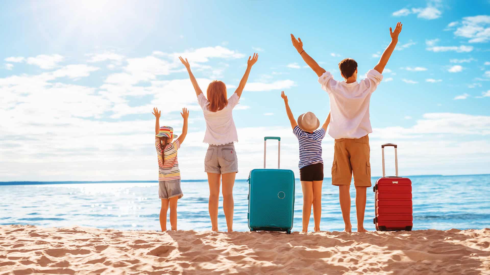 Familienhotels Europa: Familie mit Koffern am Strand