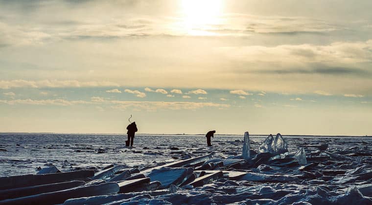 Fischer beim Eisangeln auf einem zugefrorenem See.