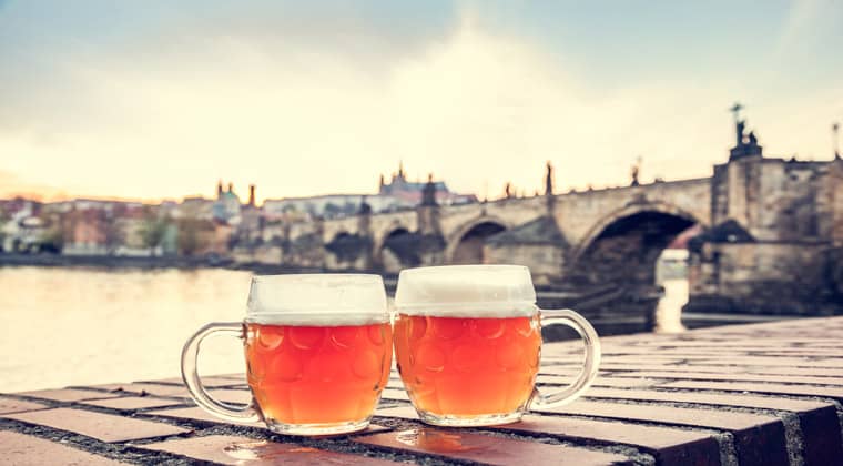 Zwei Biergläser, im Hintergrund die berühmte Karlsbrücke in Prag,Tschechien.