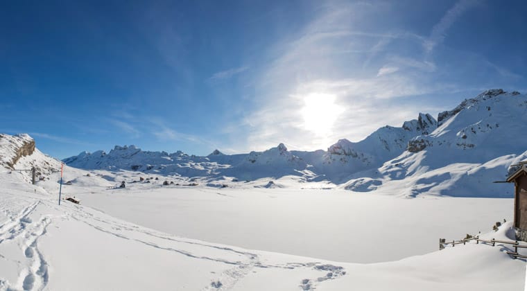 Blick auf den verschneiten Melchsee in der Schweiz, umgeben von einer traumhaften Berglandschaft.