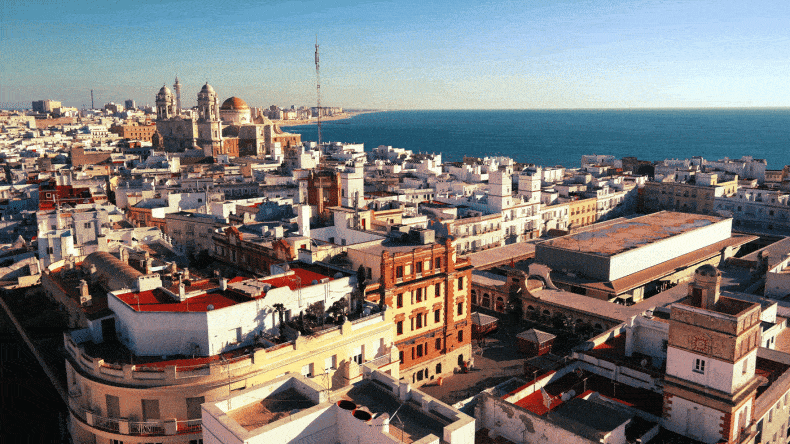 Blick über Cádiz, die Altstadt, Markthalle, die imposante Kathedrale sowie im Hintergrund der kilometerlange Strandabschnitt der Neustadt – fotografiert von dem Torre Tavira in der Altstadt, dem besten Aussichtspunkt über die Stadt.