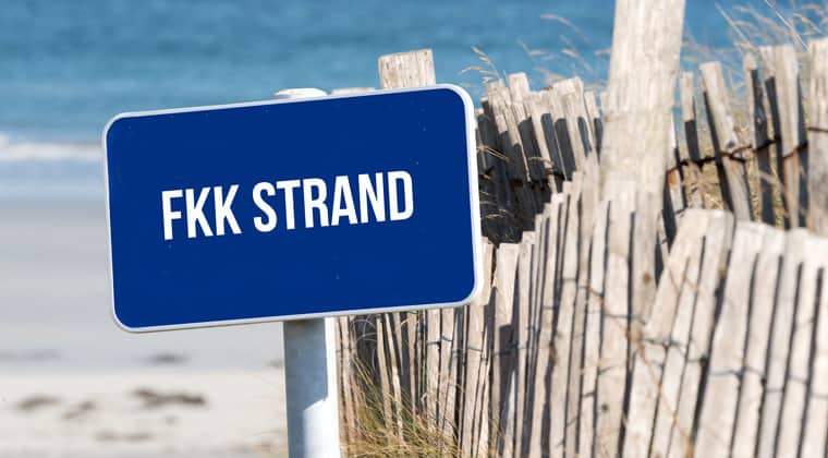 Strand, Meer und ein Schild mit dem Hinweis auf FKK Strand