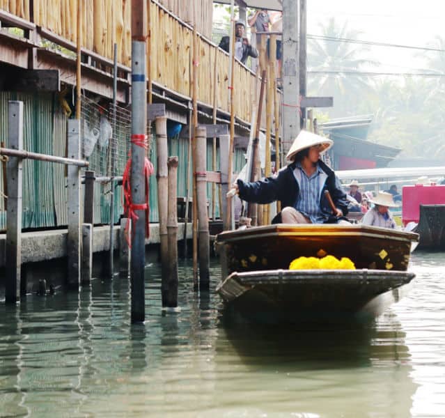 Wie in Venedig schippern die Thai-Boote an Pfählen und Häusern im Wasser vorbei