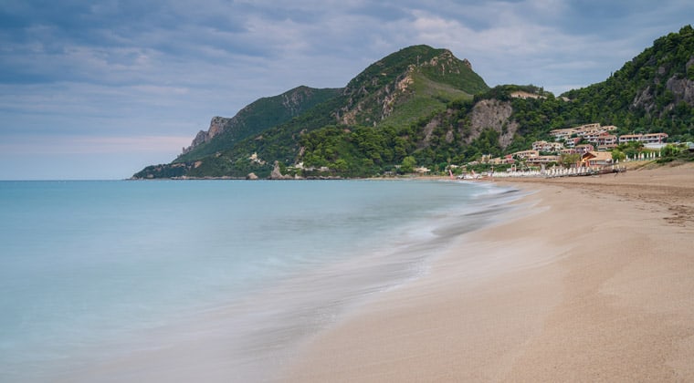 Der lange Glyfada Beach auf Korfu bietet alles was man sich wünscht: einen schönen Strand, blaues Meer und Restauration umgeben von Traumkulisse