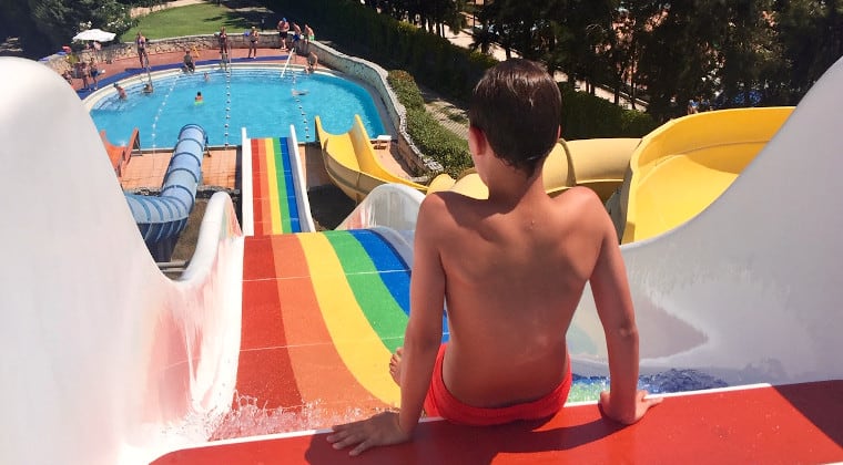 Kind rutscht eine Wasserrutsche runter.