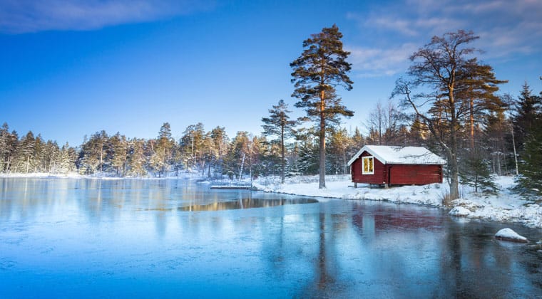 Schweden- Winterlandschaft mit einsamer Holzhütte am See