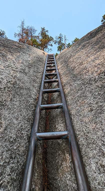 Blick auf eine in einem Felsen eingelassene Leiter auf dem Wanderweg Stawamus Chief Trail, British Columbia, Kanada