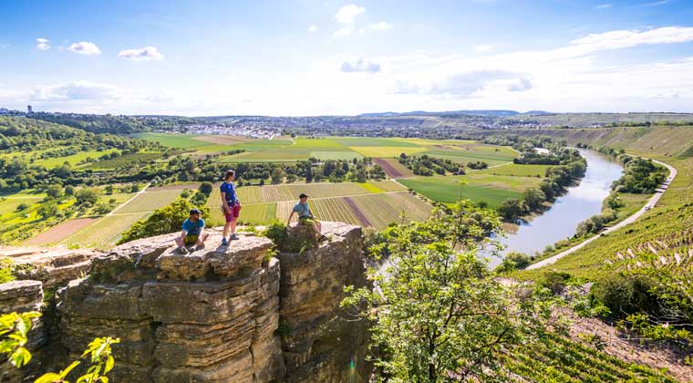 Drei Wanderer oben auf dem Felsen genießen den Blick auf die schöne Landschaft in Hessigheim in Deutschland
