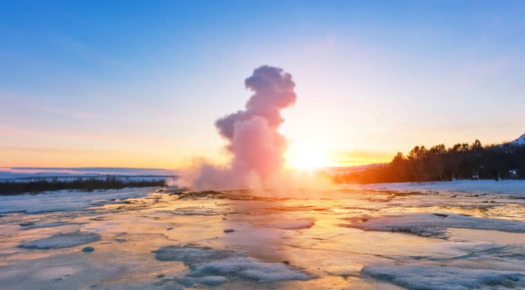 Blick auf einen heißen Geysir bei Sonnenuntergang in Islands