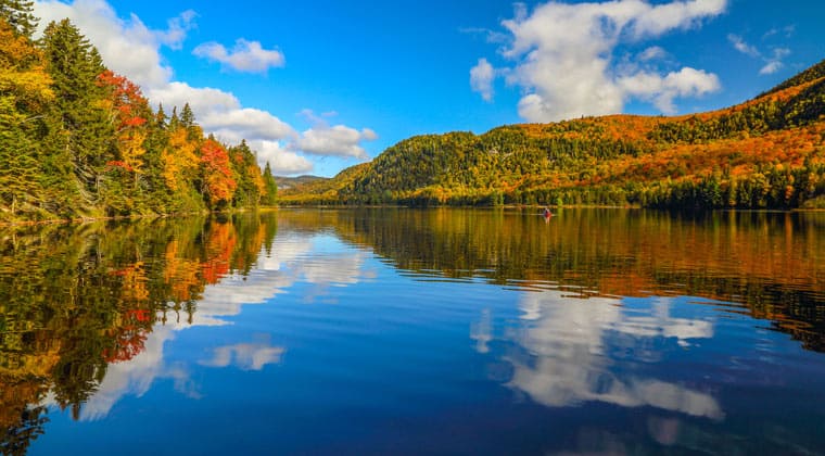 Kanada zur Zeit des Indian Summers. Die rot-gelb gefärbten Wälder spiegeln sich wunderschön in einem See.