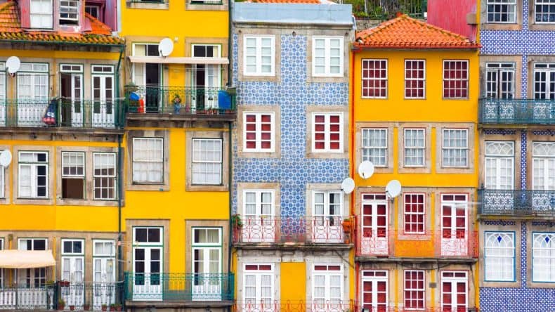 Blick auf bunte Häuser im alten Zentrum von Porto in Portugal. Die Fassaden der Häuser sind mit unzähligen Wandkacheln verziert.