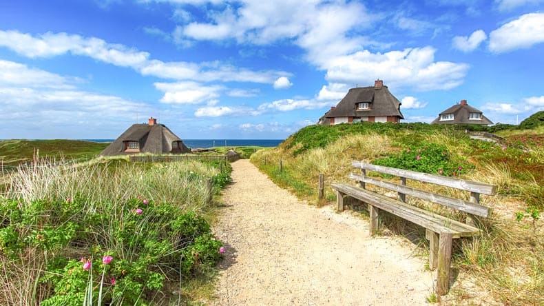 Reetgedeckte Häuser, die so typisch für die nordfriesische Insel Sylt in Schleswig-Holstein an der Nordsee sind.
