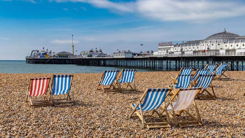 Blick auf den breiten Kiesstrand von Brighton mit dem bekannten Brighton Palace Pier.