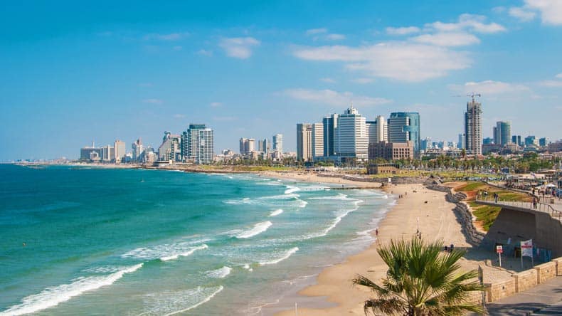 Blick auf einen der Strände Tel Avivs in Israel mit Hochhäusern im Hintergrund.
