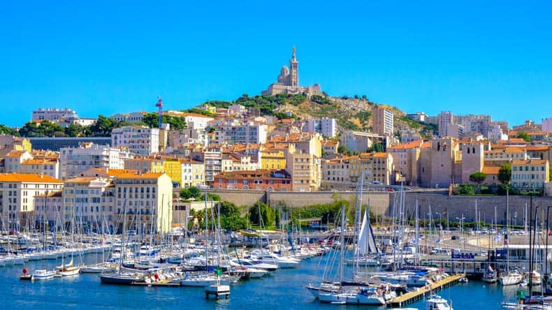 Blick auf den Marseille-Damm mit Yachten und Booten im Alten Hafen und Notre Dame de la Garde im Hintergrund, Vieux-Port de Marseille, Frankreich.