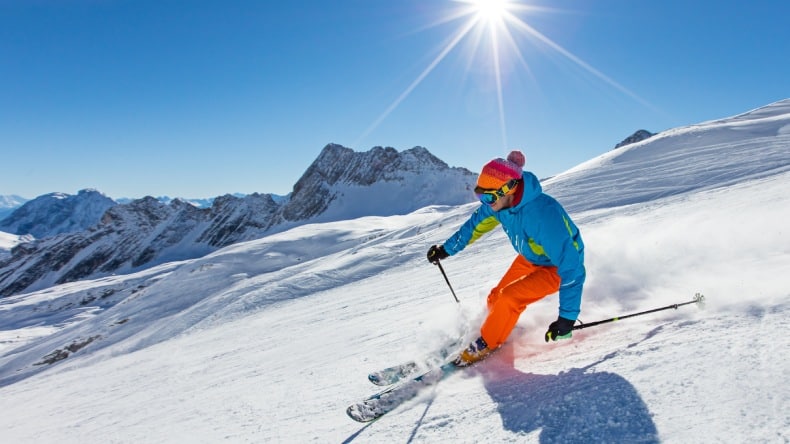 Skifahrer auf einer verschneiten Skipiste beim Skifahren.
