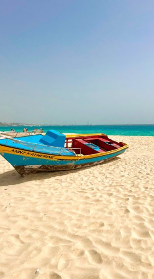 Türkisfarbenes Boot am Strand in der Nähe von Santa Maria auf der Insel Sal.