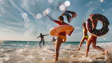 Lustige Menschengruppe im Urlaub läuft ins Meer