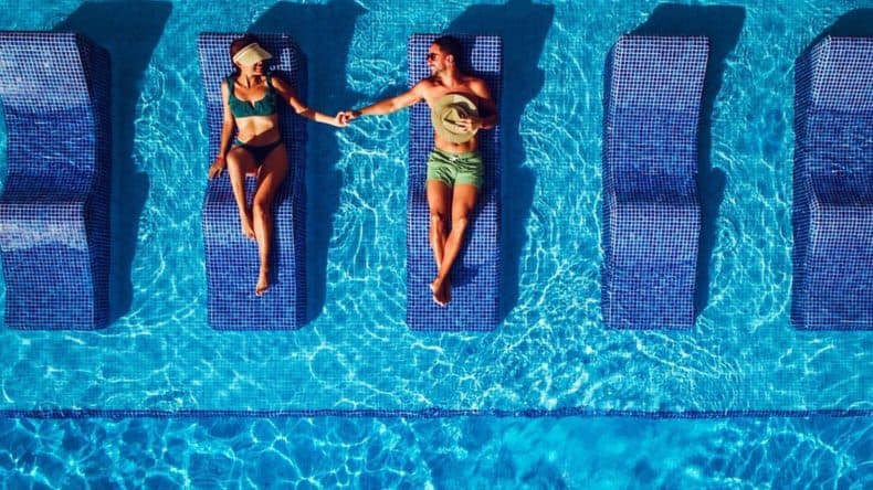 Drohnenfoto von zwei Menschen am Pool im Hotel Riu Ventura