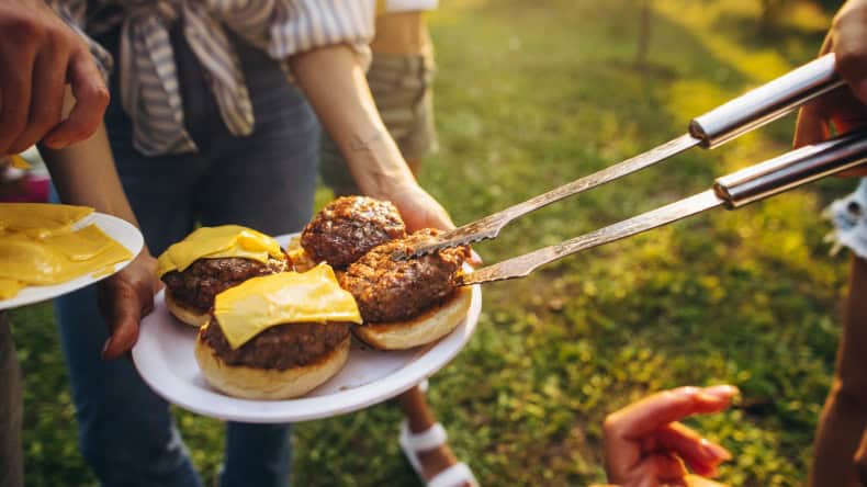Burger auf einem Teller mit Grillzange