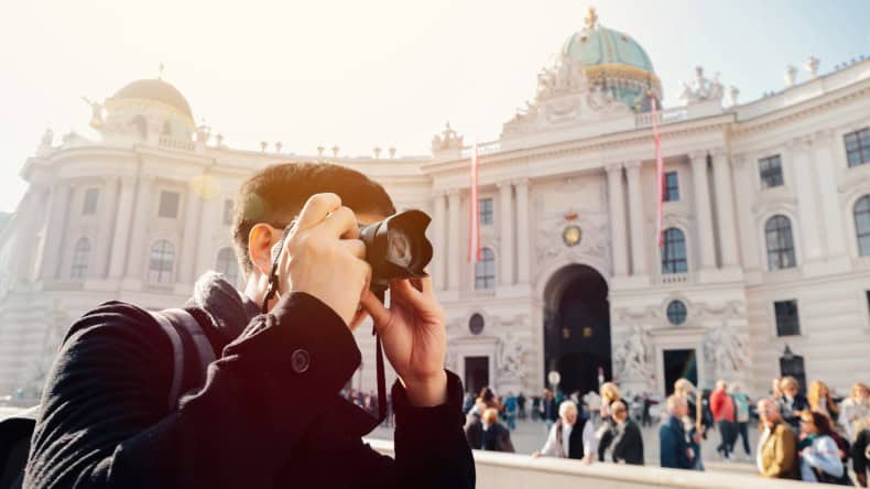 Junger Mann fotografiert die Hofburg in Wien.