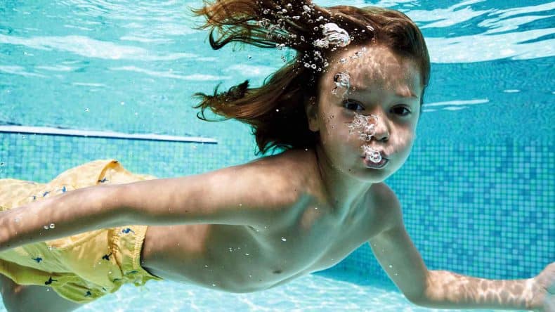 Junge taucht im Pool