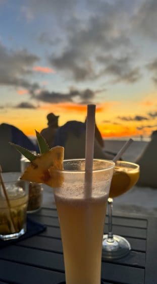 Zum Sonnenuntergang am Strand vom ROBINSON NOONU einen Cocktail genießen.