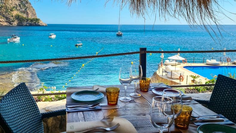 Blick auf einen gedeckten Tisch in einem Strandrestaurant mit Meerblick, Mallorca, Balearen