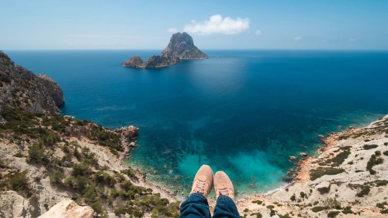Blick auf eine Bucht, türkisfarbenes Meer und die Insel Es Vedra, Ibiza, Balearen
