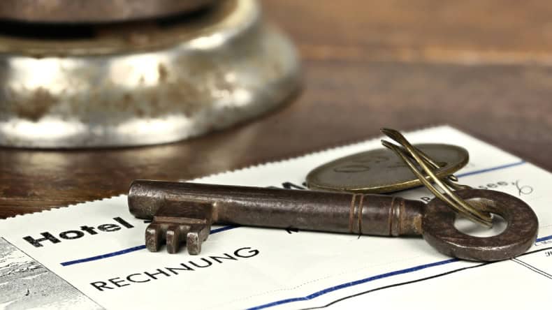 Blick auf einen Zimmerschlüssel an der Rezeption und eine Hotelrechnung, Kurtaxe