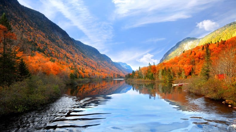 Blick auf einen See und bunte Wälder, blauer Himmel mit Schleierwolken, Indian Summer, Parc de la national Jacques Cartier, Quebec, Kanada