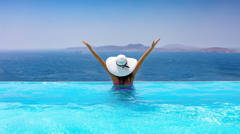 Infinitypool, Frau mit Sonnenhut, Blick aufs Meer