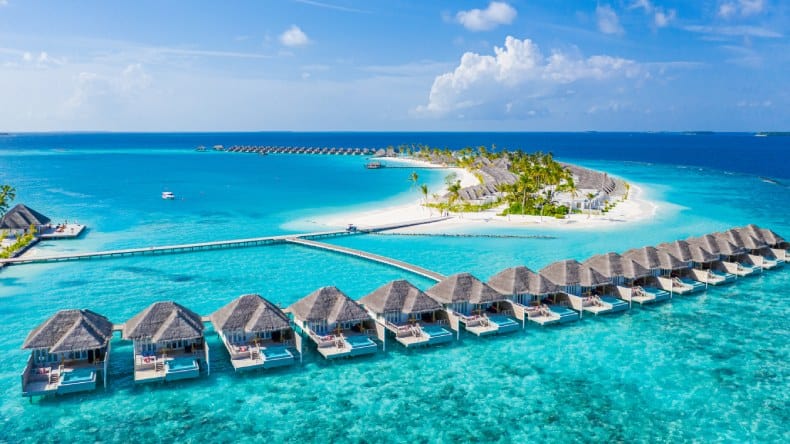 Insel mit weißem Sand, Kokospalmen, türkisfarbenes Meer, Overwater Bungalows, Malediven, Indischer Ozean