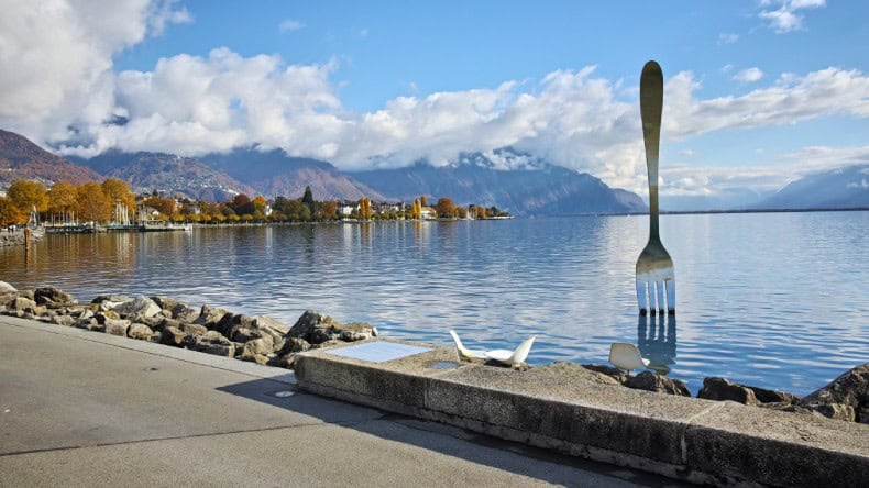 Blick auf eine etwa 8 Meter hohe Metall-Gabel, die am Ufer des Genfer Sees im Wasser steckt, Kunstobjekt, Genfer See, Vevey, Schweiz