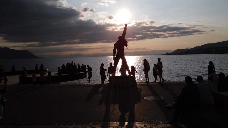 Blick auf eine Statue von dem Sänger Freddy Mercury am Ufer des Genfer Sees in Montreux, Sonnenuntergang, Schweiz