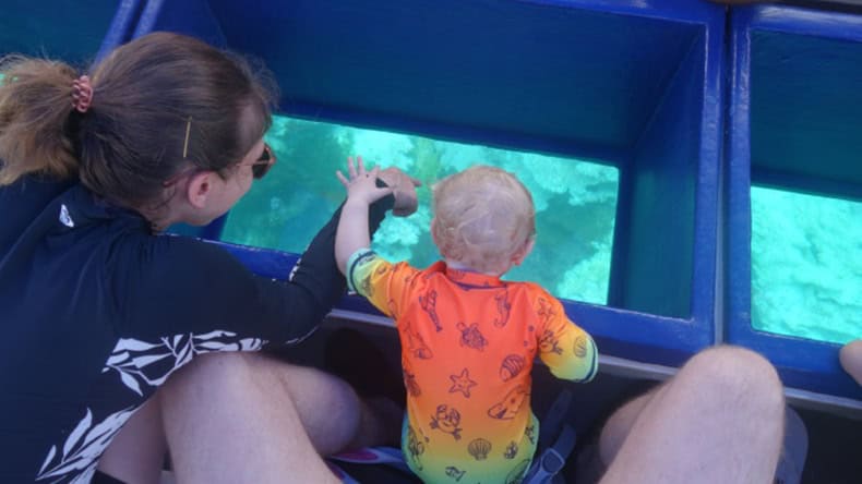 Blick mit dem Kind durch den Boden des Glasbodenboot