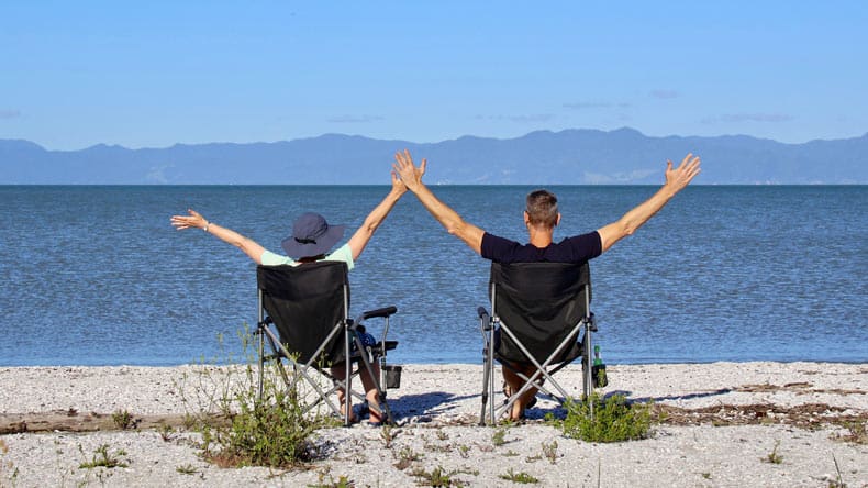 Zwei Personen im Camperstuhl am Strand