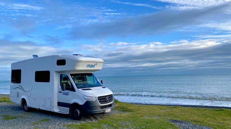 Camper in Neuseeland steht am Strand