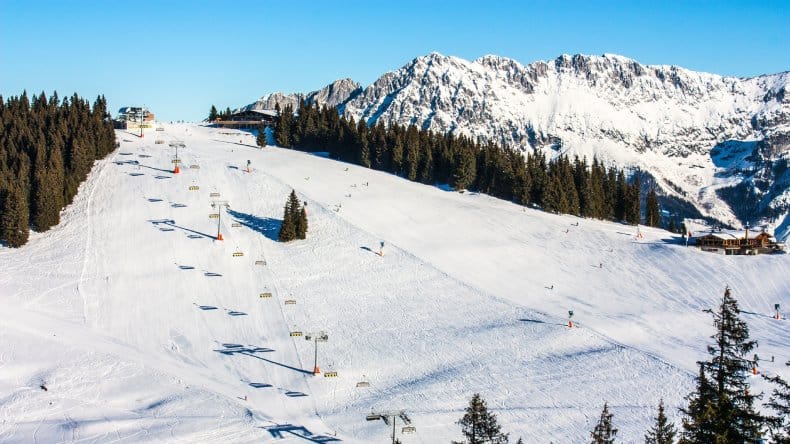 Blick auf die Skiwelt Wilder Kaiser Brixental, Schnee, Berge, Skipiste, Nadelbäume, Skistation, blauer Himmel, Österreich