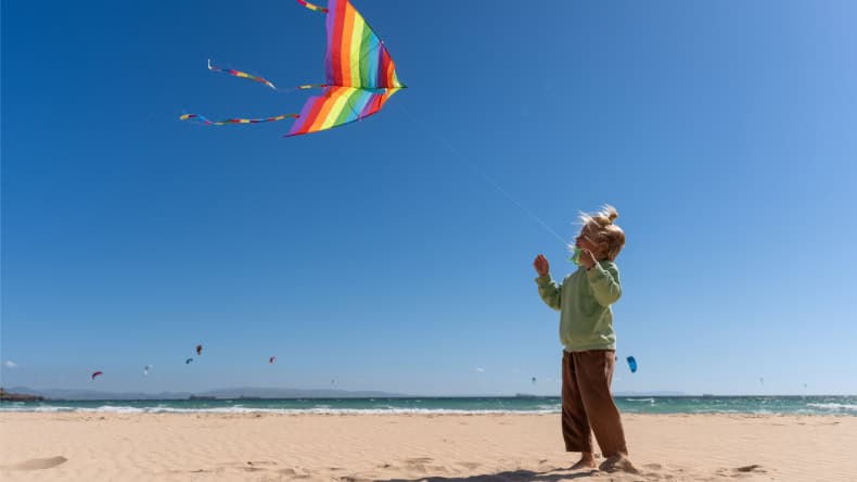 Kind mit Drachen am Strand